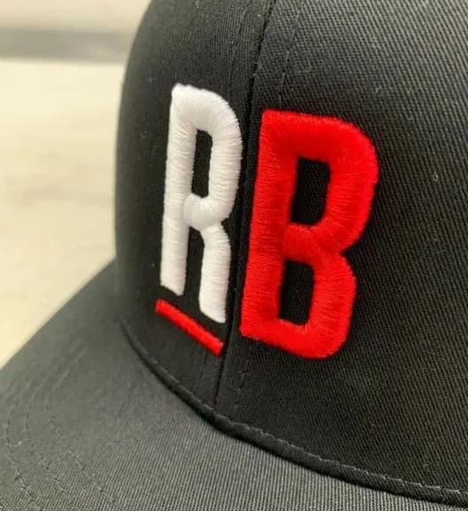 Raised red and white RB lettering embroidered on a black cap