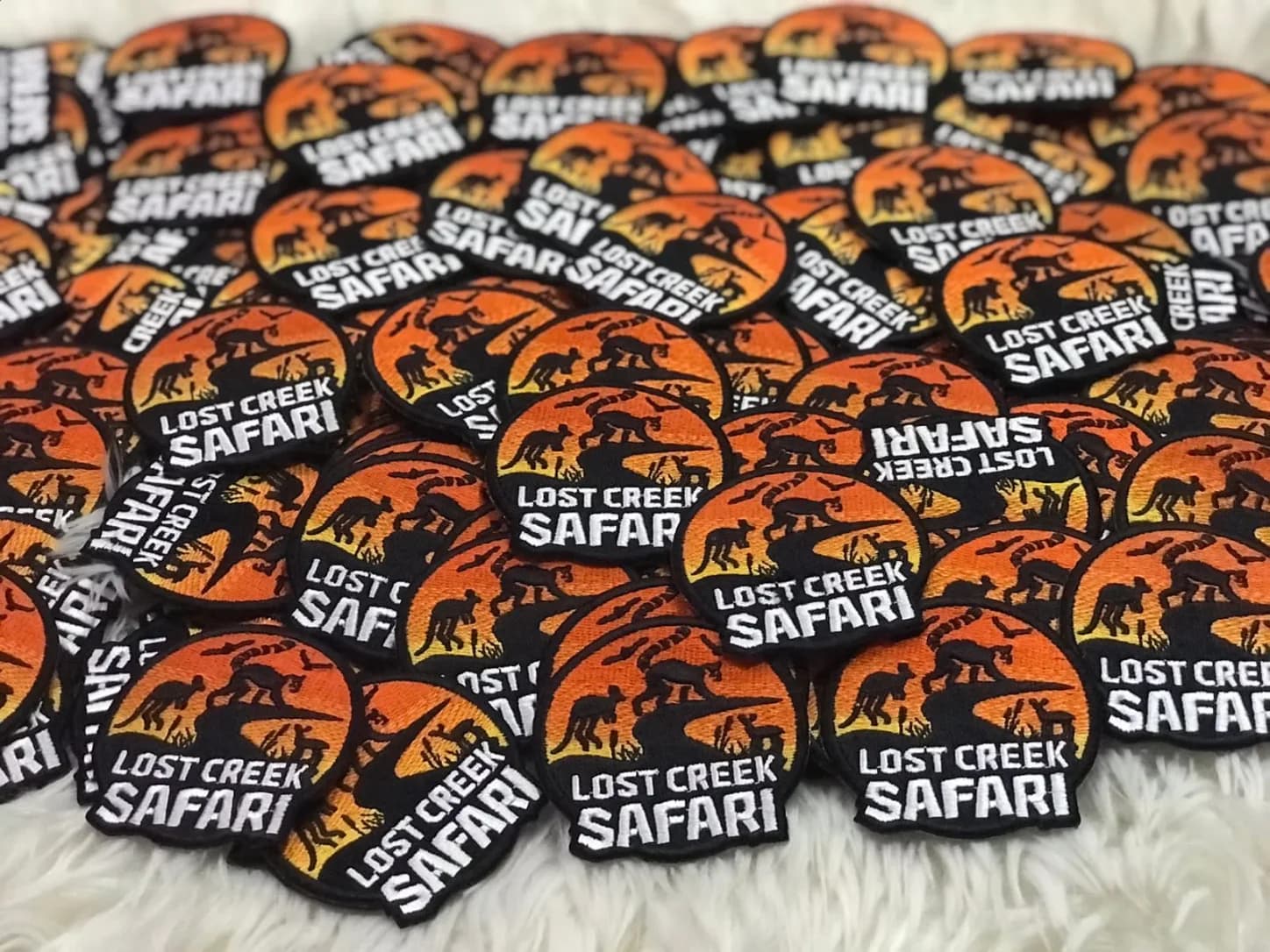 Orange and black Lost Creek Safari patches arranged in a batch